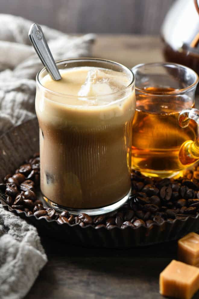 Small glass filled with iced coffee with a spoon in it.