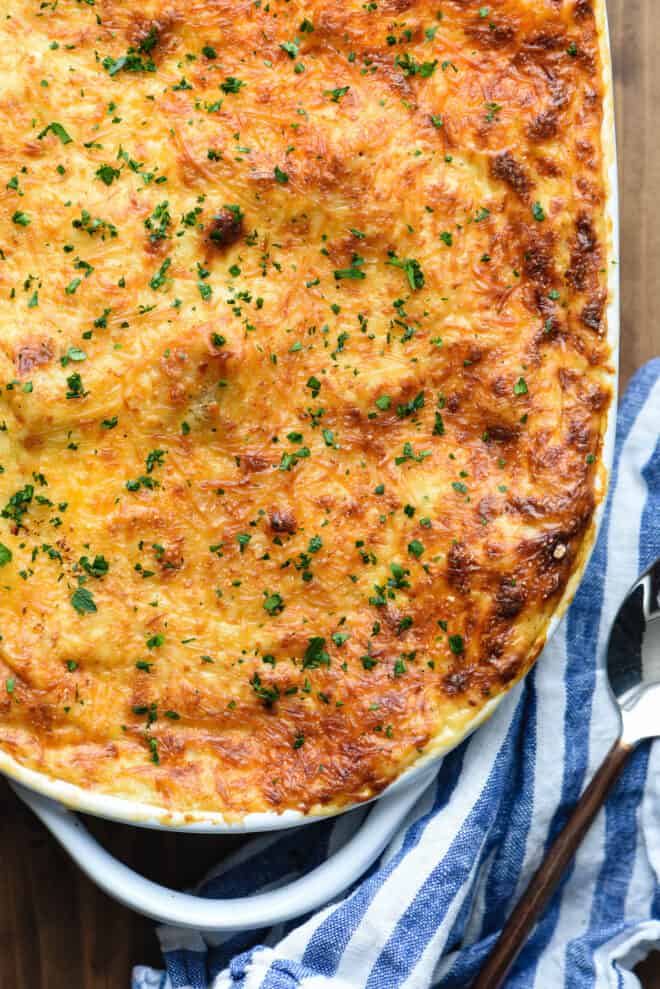 Overhead view of oval baking dish with cheese-topped baked pasta.