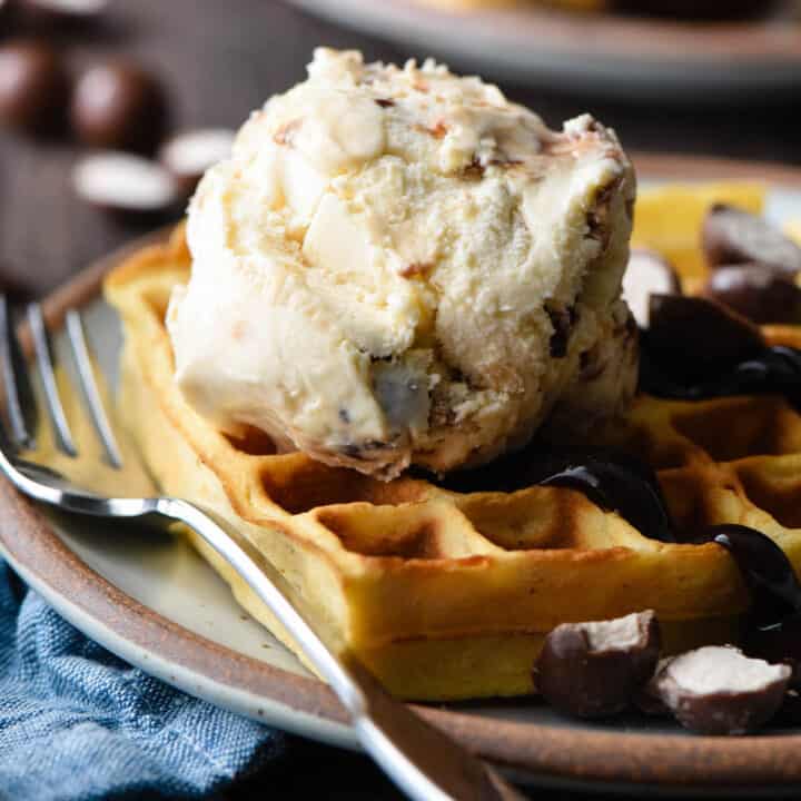 Golden brown waffle topped with hot fudge and a scoop of ice cream.