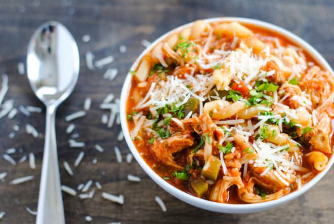 Overhead image of bowl of crockpot chicken parmesan soup and spoon.