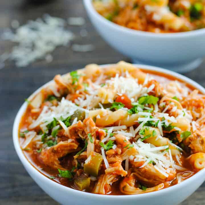 Bowl of chicken parmesan soup sprinkled with parmesan cheese.