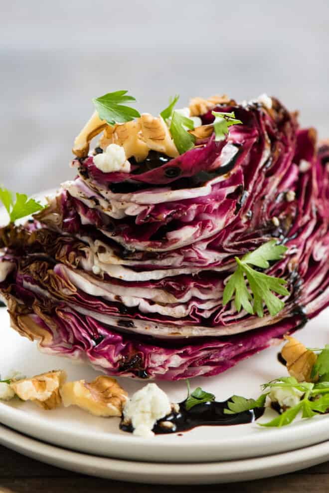 Wedge of Italian chicory topped with balsamic glaze, nuts, cheese and herbs.