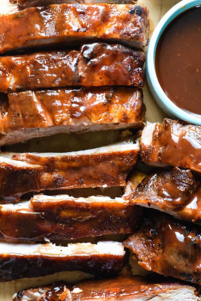 Crock pot ribs cut up and brushed with barbecue sauce.