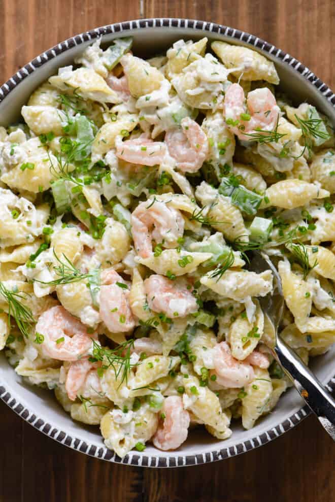 Serving bowl filled with shrimp and crab pasta salad.