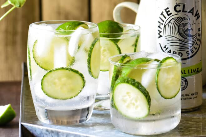 Closeup on three White Claw cocktails garnished with limes and cucumbers.