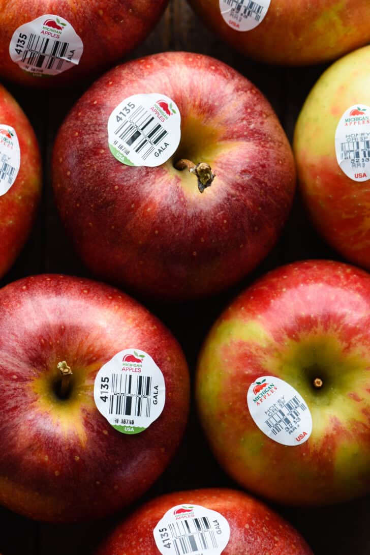 A closeup photo of several red apples with Michigan Apples bar code stickers on them.