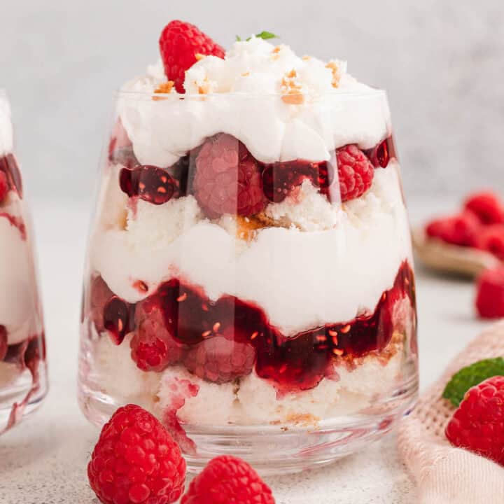 A stemless wine glass filled with raspberry trifle.