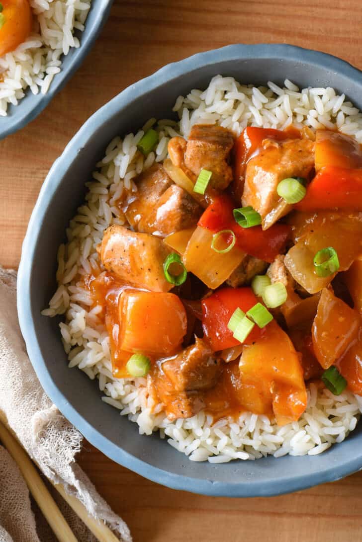 Slate blue bowl filled with white rice and Instant Pot sweet and sour chicken.