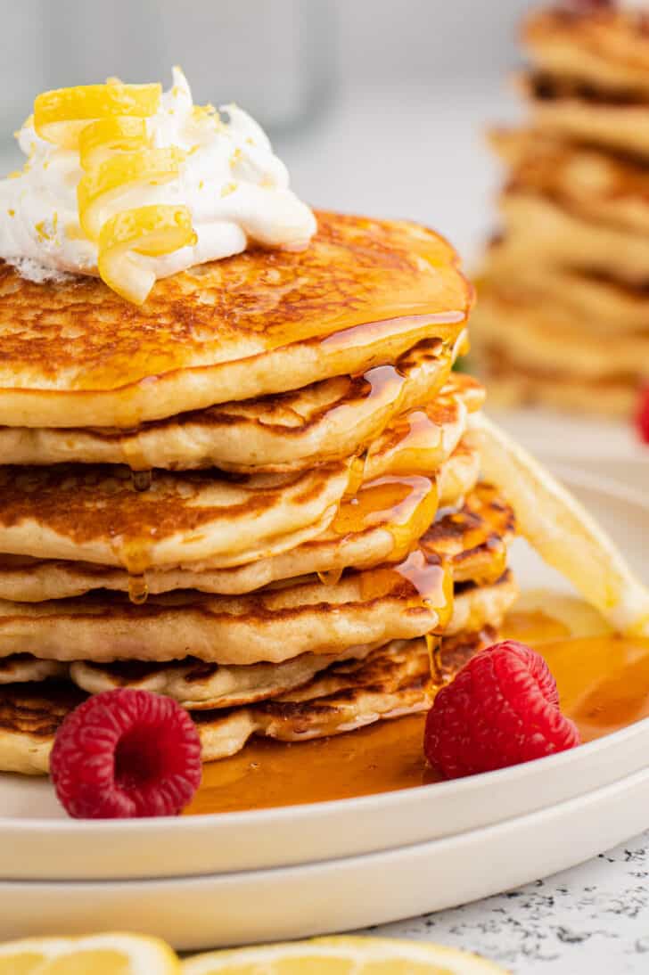 A stack of lemon pancakes drizzled with syrup.