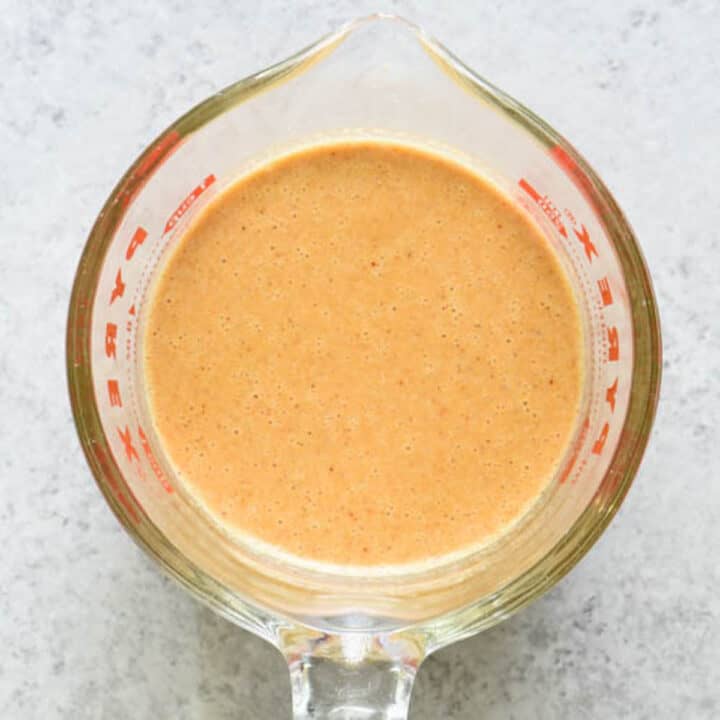 Orange liquid in a glass Pyrex measuring cup.