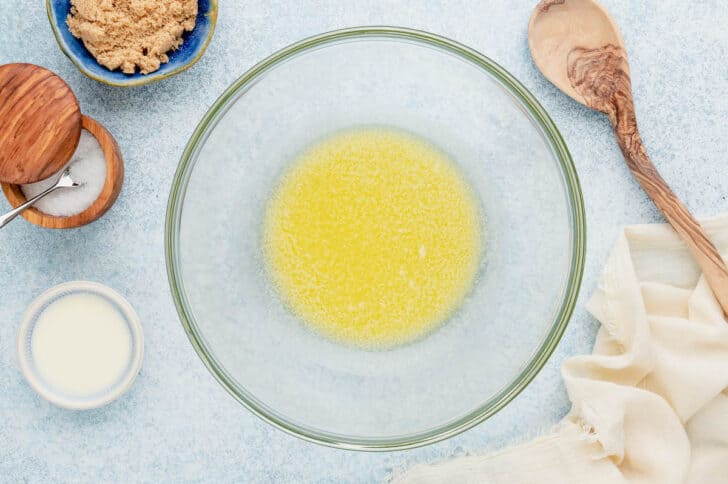 A glass mixing bowl filled with melted butter.