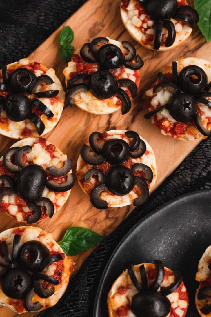 Pizza spiders for Halloween, made with mini pizza bagels and black olives.