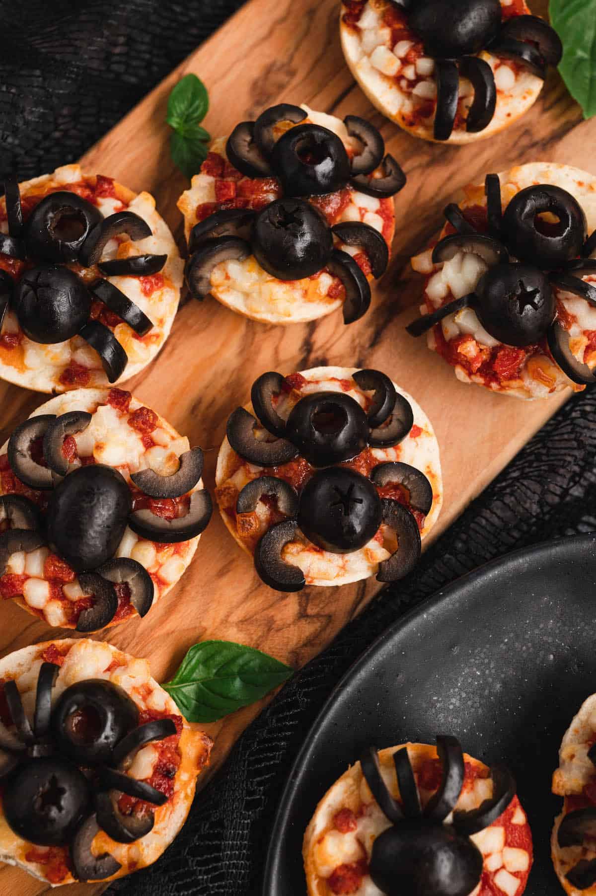 Halloween pizzas made with mini pizza bagels and black olives.
