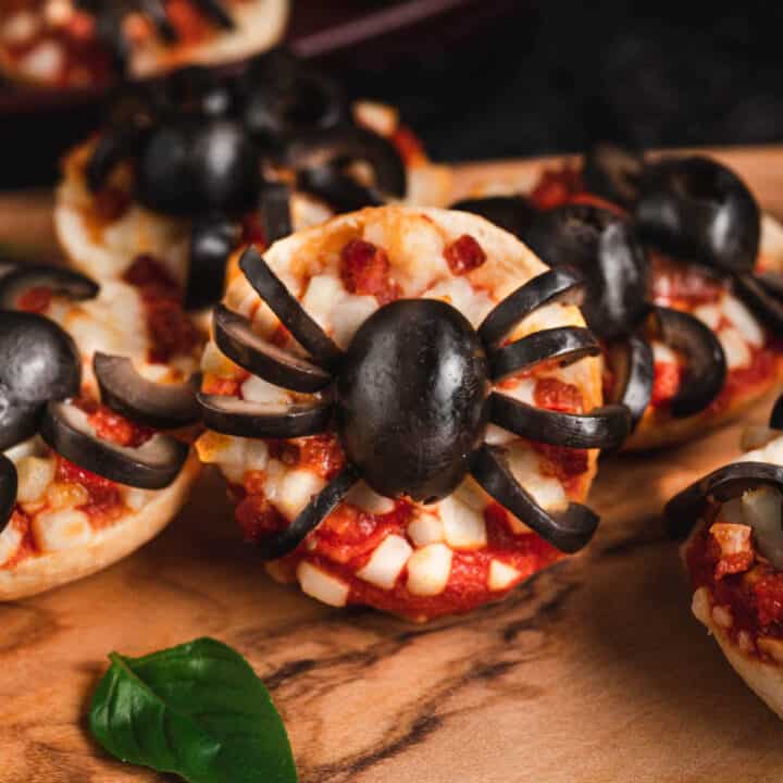 Halloween pizzas made with mini frozen pizza bagels and black olives cut to look like spiders.