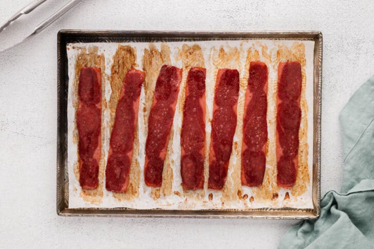 A rimmed baking pan with the finished results of the best way to cook turkey bacon.