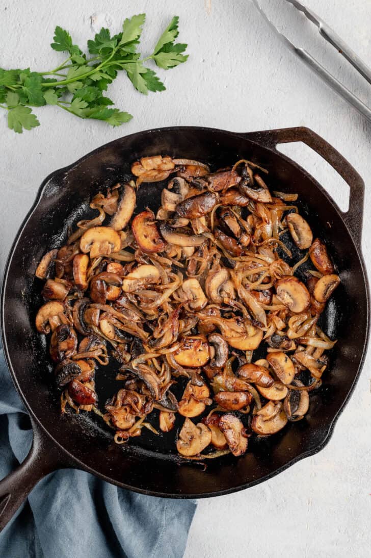 Sauteed mushrooms and onions in a cast iron skillet.