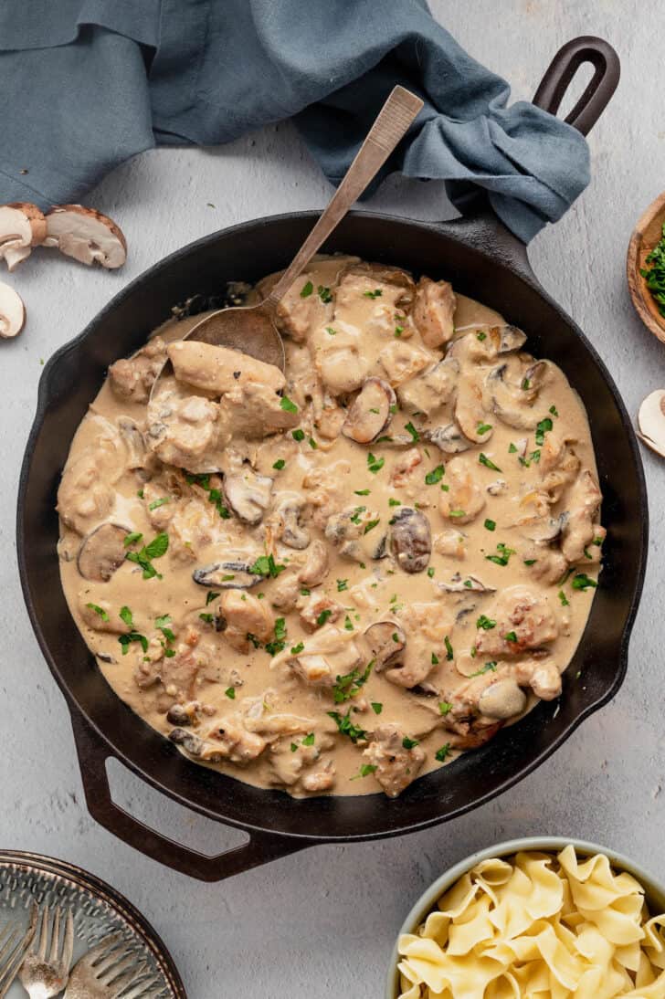 Creamy chicken and mushroom stroganoff sauce in a cast iron skillet.