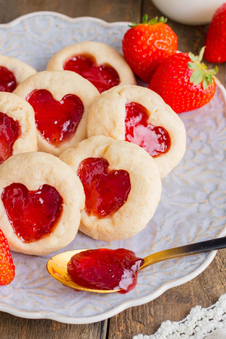 Heart jam cookies made with shortbread and strawberry jam, on a decorative plate.