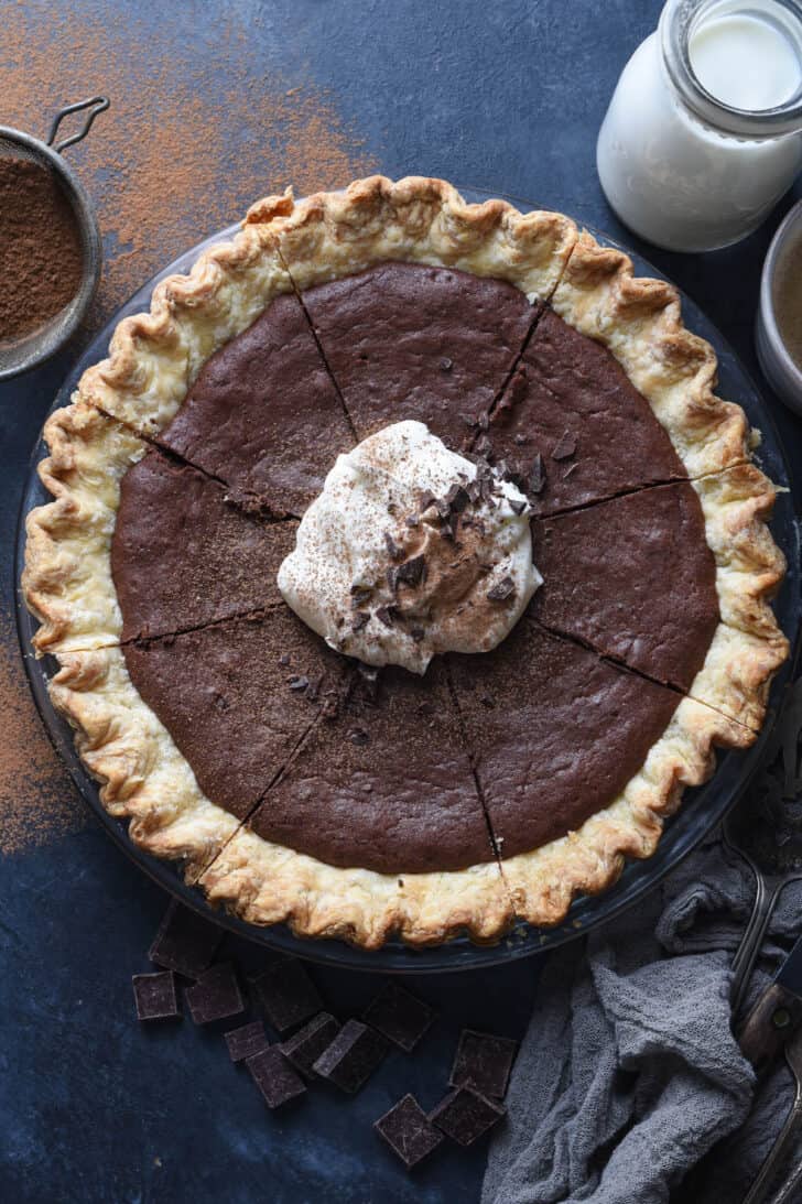 A brownie pie topped with whipped cream and chocolate shavings.