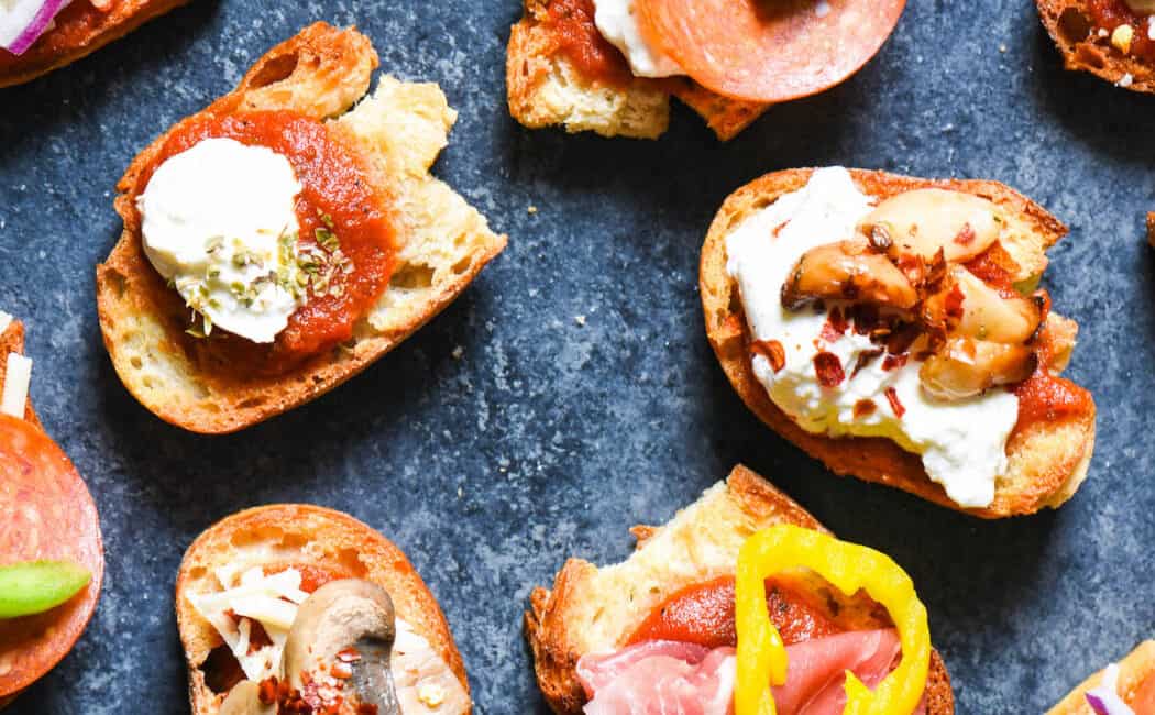 Crostini pizzas made from toasted baguette slices topped with tomato sauce, cheese and a variety of meat and vegetable toppings.