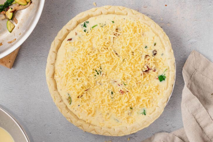 Egg and milk mixture covered in cheese in a pie shell.