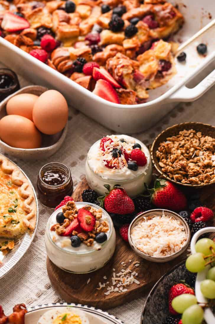 Brunch foods including small bowls of yogurt and berries.