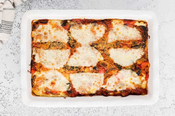 A vegetable lasagna recipe in a white baking dish.