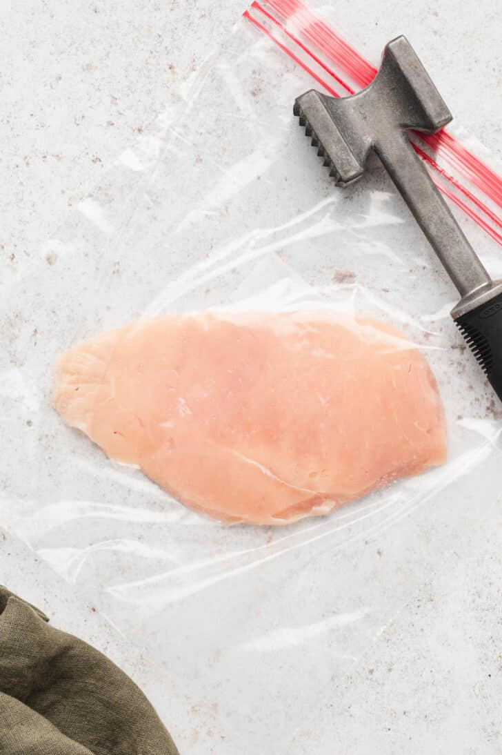 A pounded out chicken breast in a zip top bag.