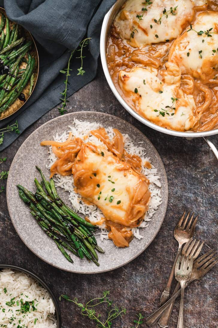 Skillet French Onion Chicken over rice on a gray plate with a side of green beans.