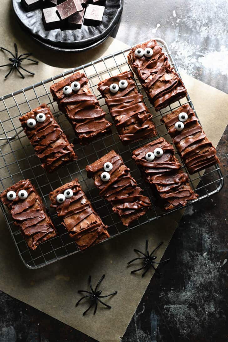 Halloween brownies that resemble mummies on a metal cooling rack.
