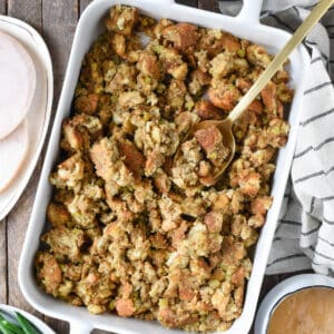 Overhead Thanksgiving tablescape with stuffing, turkey, cranberry sauce, green beans and gravy.