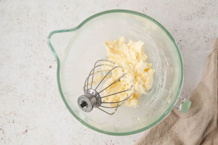 A glass stand mixer bowl filled with DIY butter.