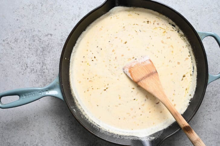 A creamy sauce mixture in a cast iron skillet.
