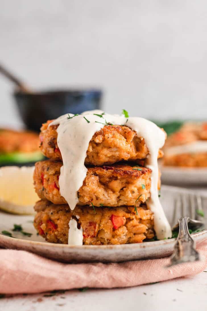 A stack of three salmon patties topped with creamy sauce for salmon patties.