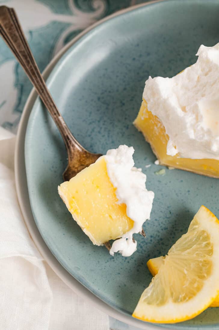 A closeup photo of a bit of a lemon meringue pie recipe on a fork.