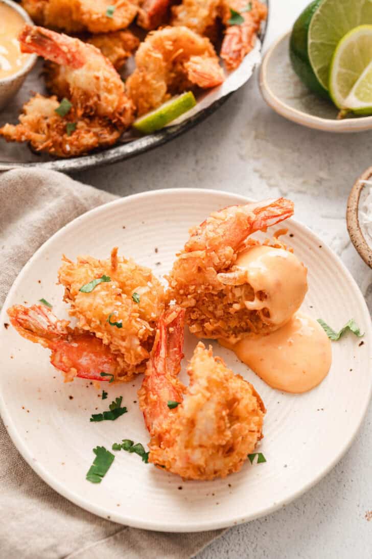 Three fried shrimp served with the best sauce for coconut shrimp on a small plate.