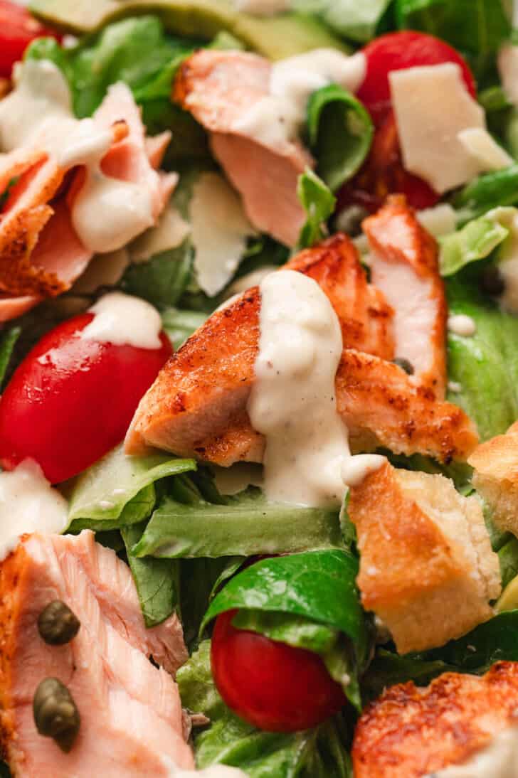 Closeup on a Caesar salad with salmon.