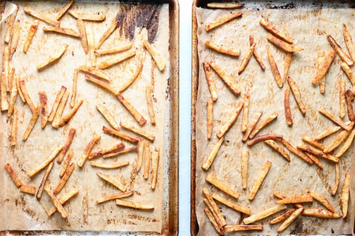 Oven baked French fries on parchment-lined baking pans.