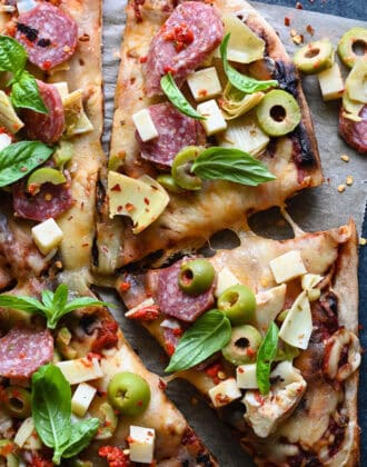 A grilled pizza topped with antipasto toppings.