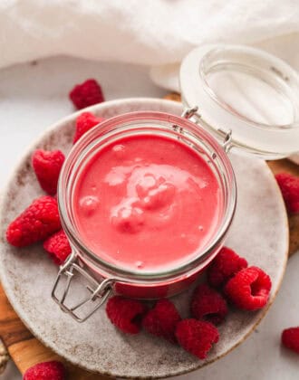 Raspberry vinaigrette in an open lidded jar.