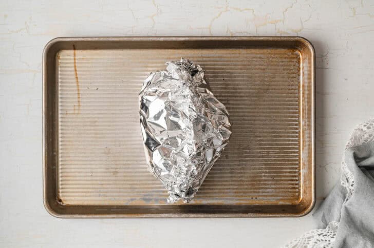 A foil packet on a baking pan.