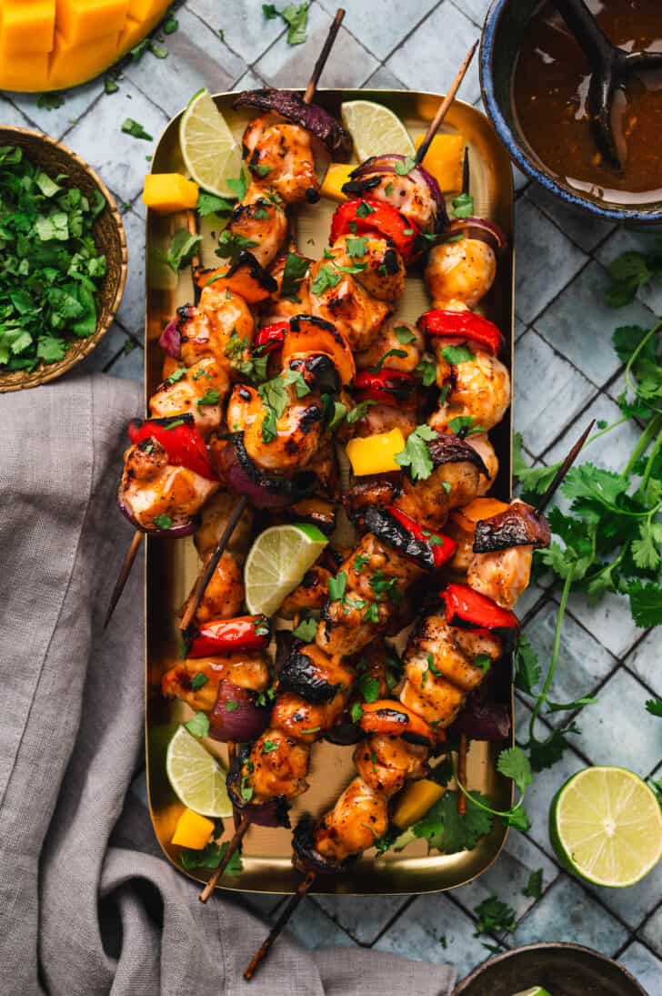 A large rectangle platter filled with chicken kabobs.