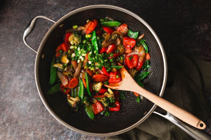 A black skillet filled with a stir fry vegetables recipe.