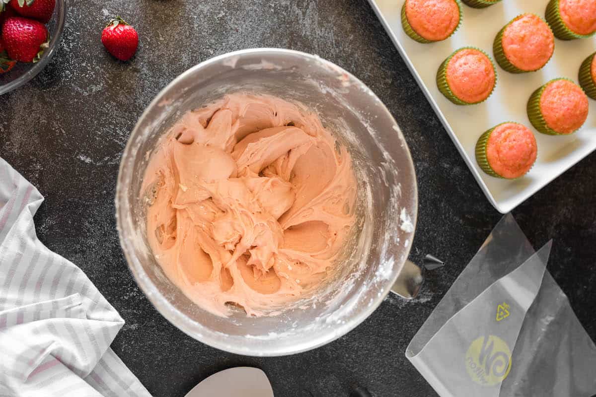 Strawberry buttercream frosting in a stand mixer bowl.