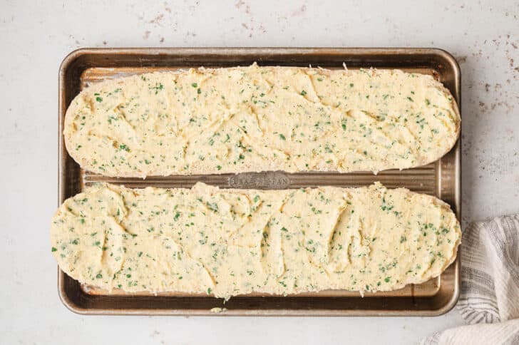 Homemade garlic bread on a rimmed baking pan, before baking.