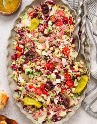 An Italian chopped salad on an oval platter with ruffled edges.