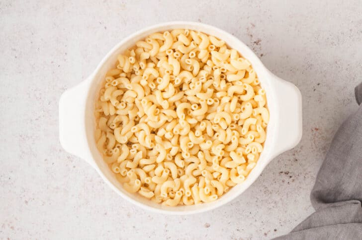 Cooked elbow noodles in a white colander.