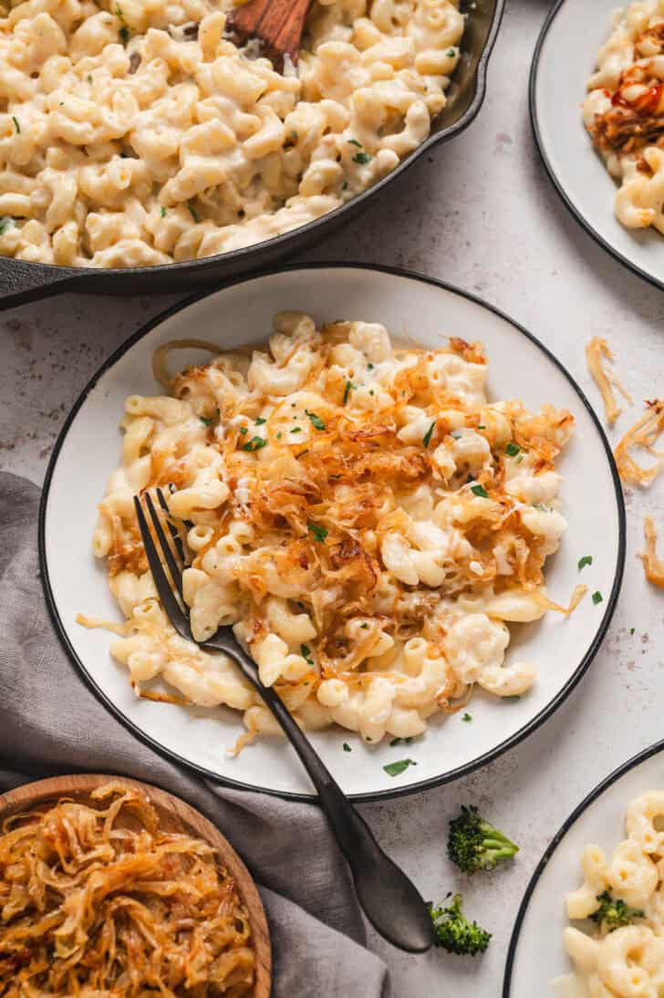 A plate of stovetop mac and cheese recipe with caramelized onions on top.