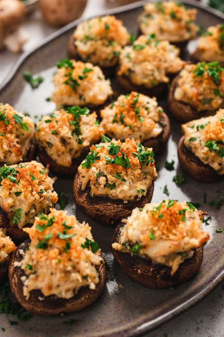 Crab stuffed mushrooms on a gray platter.