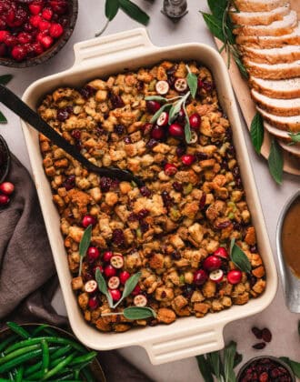 Cranberry stuffing in a baking dish surrounded with side dishes.